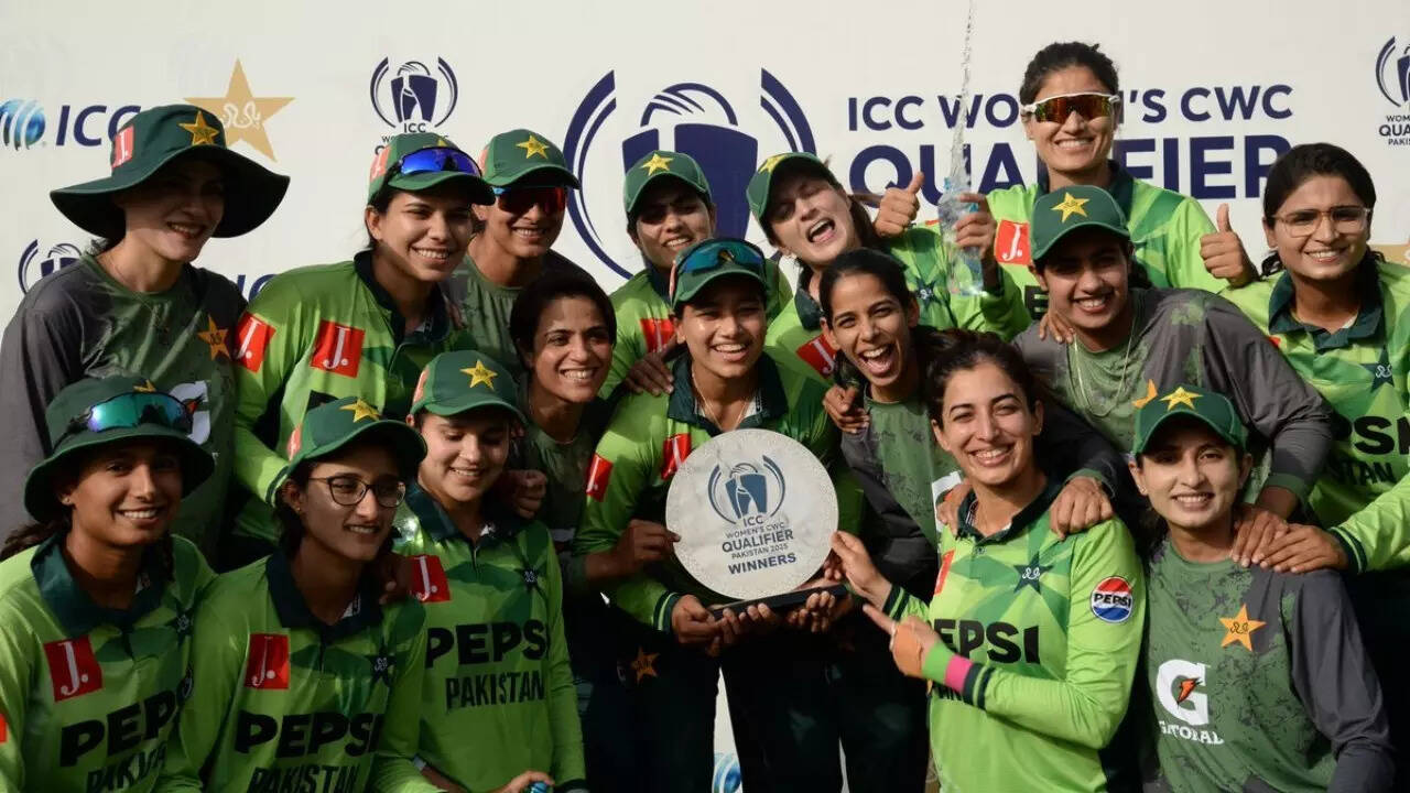 A group of Pakistan Women’s Team cricketers in green uniforms pose together, smiling and holding a winners trophy in front of an ICC World Cup Qualifier banner. | jeetwinbet.com